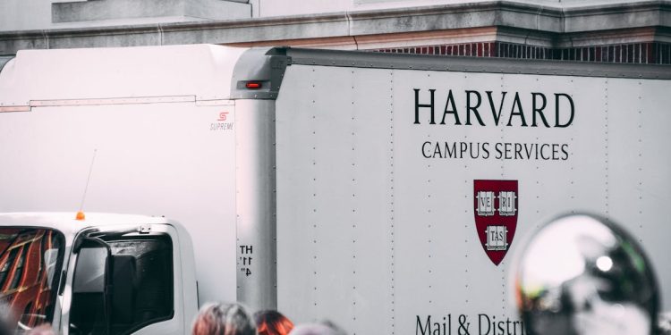 Harvard Campus Services truck in city street, showcasing delivery near university building.