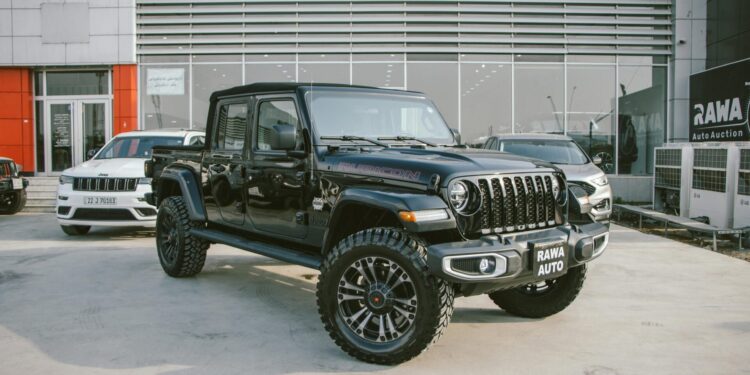Black Jeep Gladiator Rubicon showcased outside RAWA Auto Auction dealership.