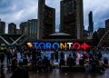 Vibrant evening at Toronto City Hall with festive crowd enjoying the cityscape.