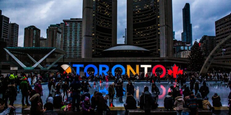Vibrant evening at Toronto City Hall with festive crowd enjoying the cityscape.
