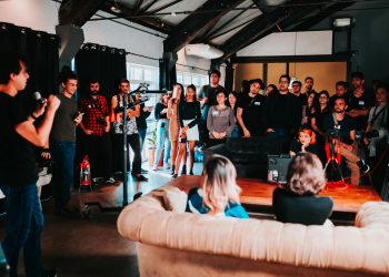 Vibrant business seminar in São Paulo with a diverse audience engaged in a speaker's presentation.