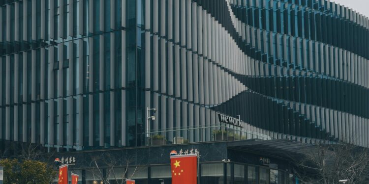 Contemporary architectural building with Chinese flags displayed prominently.