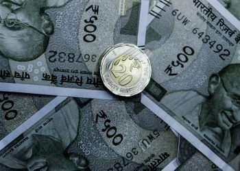 Detailed close-up of Indian 500-rupee notes and a 20-rupee coin, highlighting currency details.