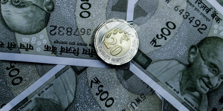 Detailed close-up of Indian 500-rupee notes and a 20-rupee coin, highlighting currency details.