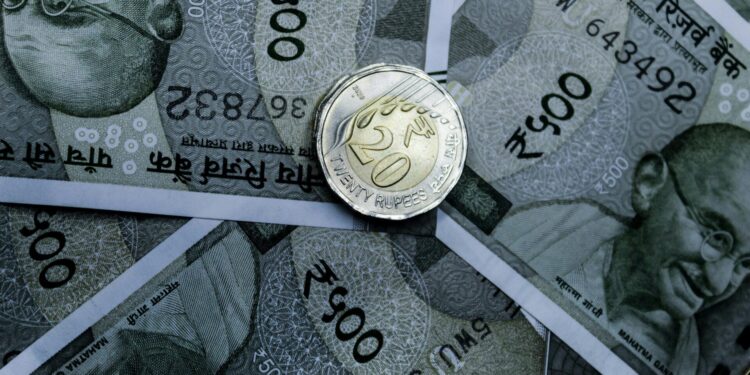 Detailed close-up of Indian 500-rupee notes and a 20-rupee coin, highlighting currency details.
