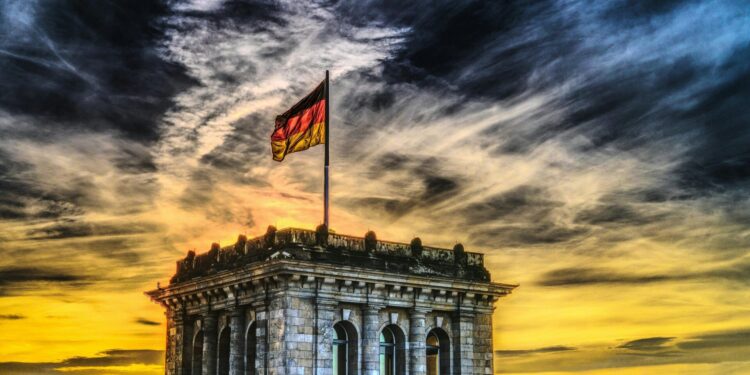 Vibrant sunset over a historic Berlin monument with the German flag waving.