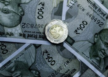 Detailed close-up of Indian 500-rupee notes and a 20-rupee coin, highlighting currency details.