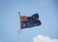 Australian national flag waving on a flagpole against a clear blue sky in Perth.