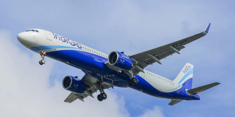 An IndiGo Airbus A320 Neo captured mid-flight against a bright blue sky, showcasing modern aviation technology.