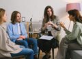 A group therapy session taking place indoors with an attentive counselor guiding the discussion.