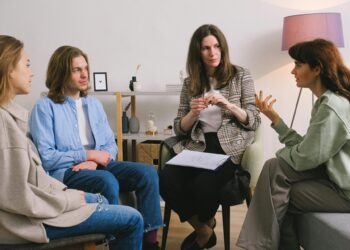 A group therapy session taking place indoors with an attentive counselor guiding the discussion.
