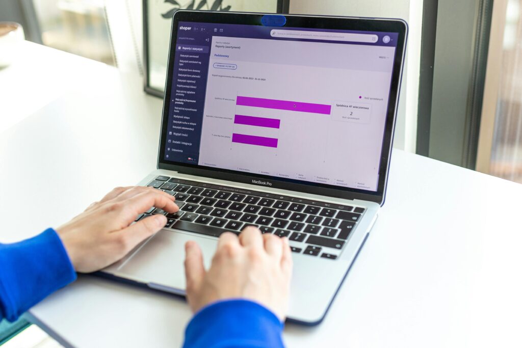 Person working on a laptop with business analytics displayed on the screen.