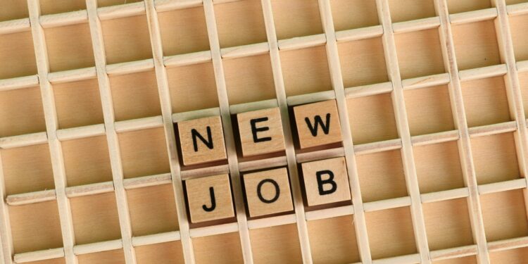 Discover the excitement of a new job with wooden letter tiles spelling 'NEW JOB' on a grid.