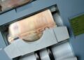 50 Euro banknotes being processed in a high-speed counting machine, showcasing technology and finance in action.
