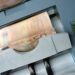 50 Euro banknotes being processed in a high-speed counting machine, showcasing technology and finance in action.