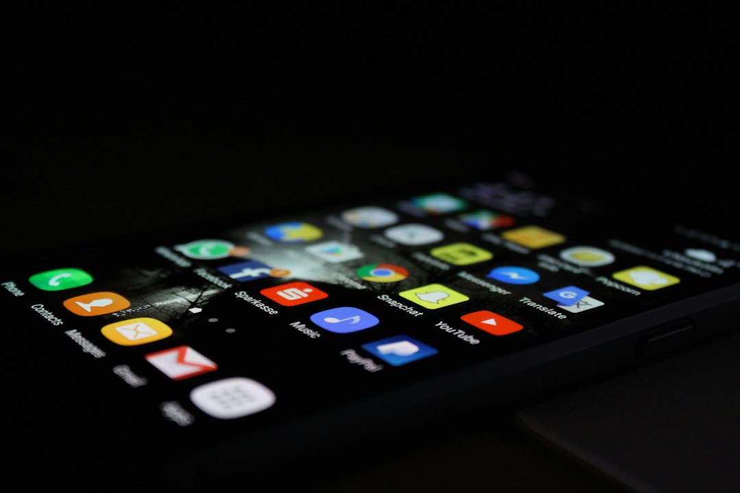 A smartphone screen glows in the dark with rows of app icons, illustrating the mobile apps Photon aims to replace with AI agents after raising $4.5M.