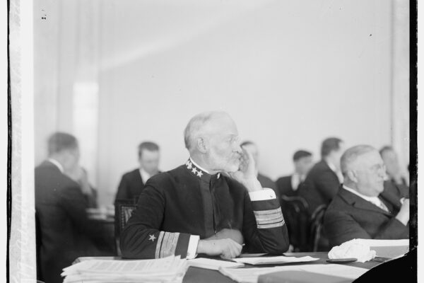 Admiral Sims testifying before a committee, illustrating a historical hearing on global risks.