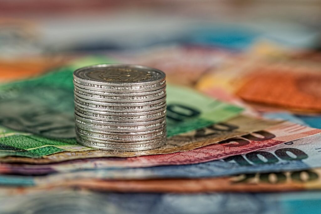 Coins and banknotes stacked together, illustrating the financial comparison of GIFT City funds.