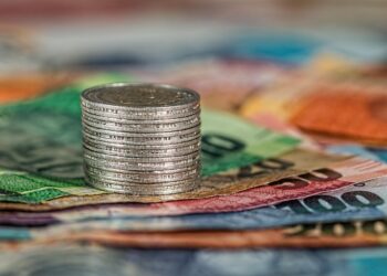 Coins and banknotes stacked together, illustrating the financial comparison of GIFT City funds.