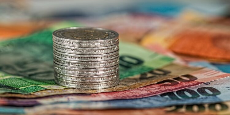 Coins and banknotes stacked together, illustrating the financial comparison of GIFT City funds.