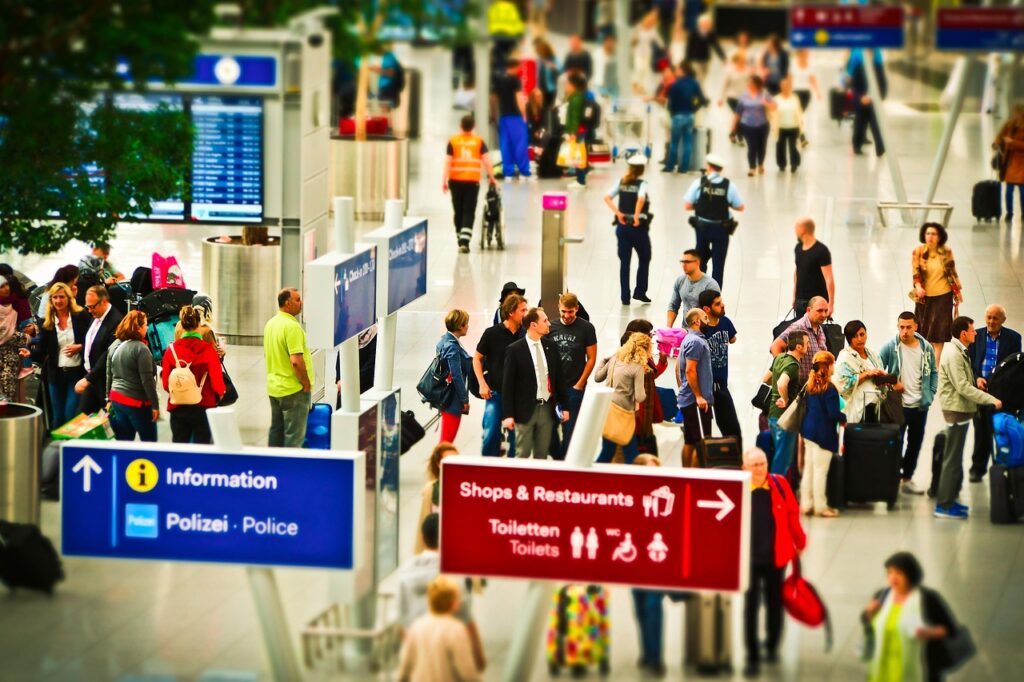 Travelers with luggage at an airport gate, illustrating Frontier's reported airfare increase.