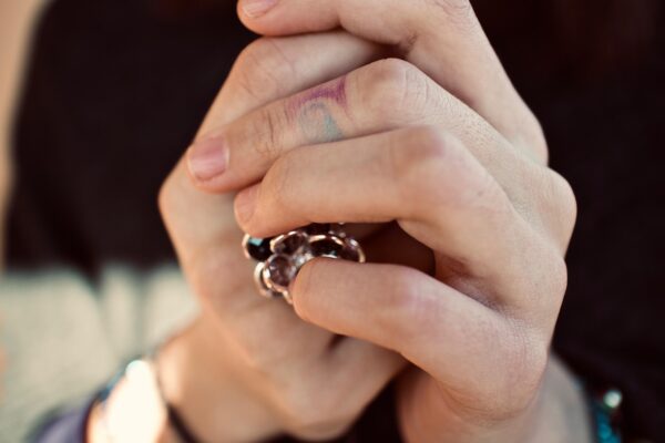 Two hands with tattoos clasped together, one wearing a ring, illustrating union solidarity in the article.