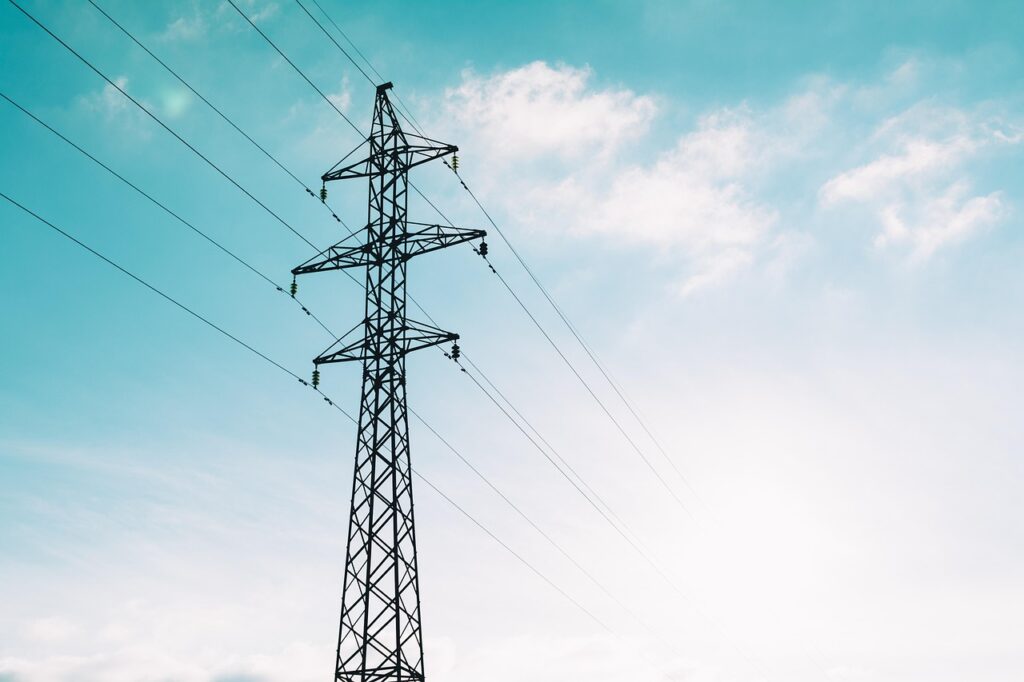 Overhead power lines and a tower against the sky, illustrating the Haryana Commission halting power licence proceedings.