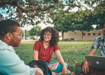 University students discussing in a grassy campus field, illustrating applications for UGC's 2027 ODL and online programmes.