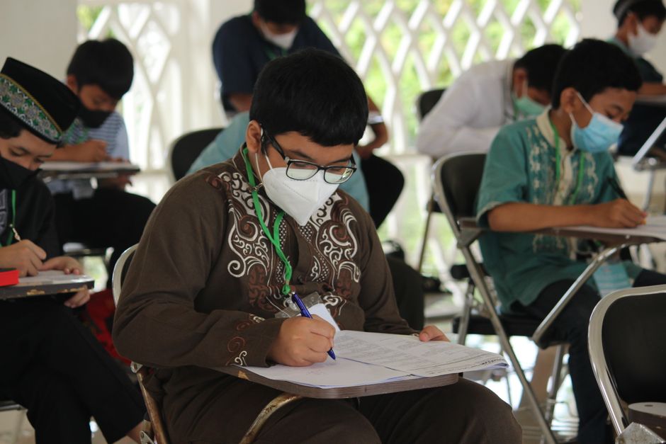 Students wearing face masks write exams, illustrating JEE Main 2027 registration.