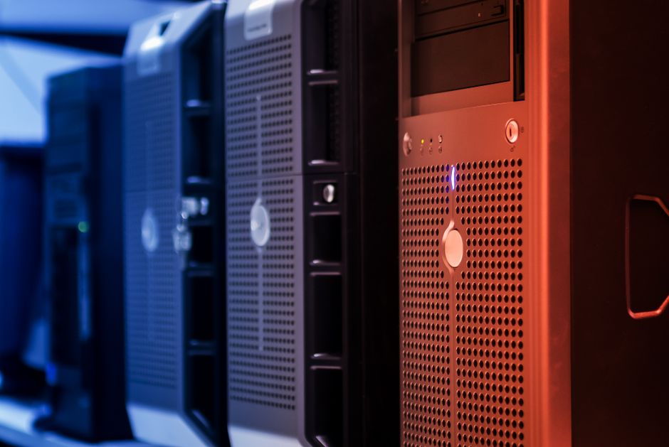 Tower servers with blue and red lighting in a data center, illustrating the role of AI infrastructure in global risks.