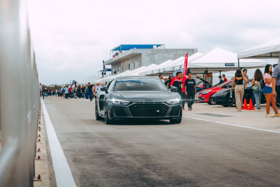 A sleek black luxury sports car showcased at an outdoor automotive event