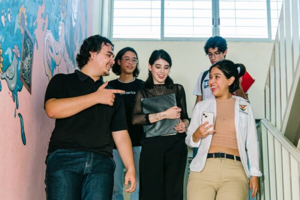 Diverse university students talking on campus stairs in Culiacán, illustrating international students' economic impact in the UK.