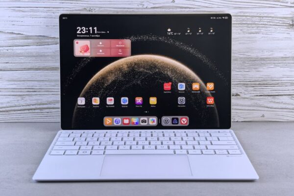 A sleek tablet with a keyboard showing a digital interface on a wooden background, illustrating the touchscreen MacBook Pro launch.