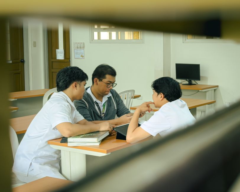 Three students collaborating on a classroom project, illustrating college teamwork amid digital wagering concerns.