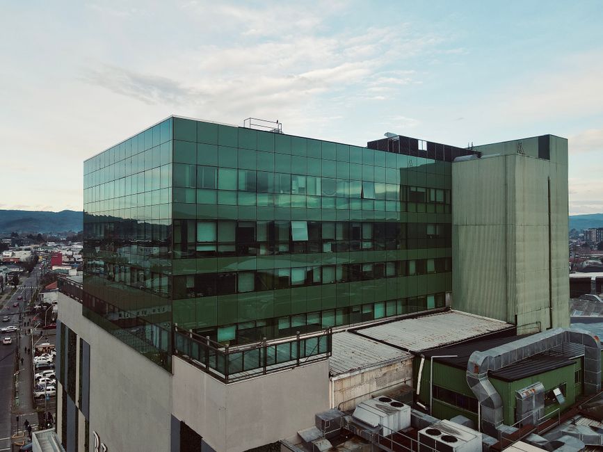A modern glass office building seen from above with a city backdrop under a clear sky, illustrating India's potential for data centre investment.