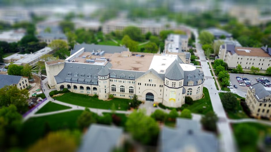 Aerial view of a university campus with modern buildings and greenery, illustrating an ILO study on women's AI exposure risk.