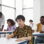 Diverse college students focused on an exam in a classroom, illustrating the UPSC NDA and CDS exam context.
