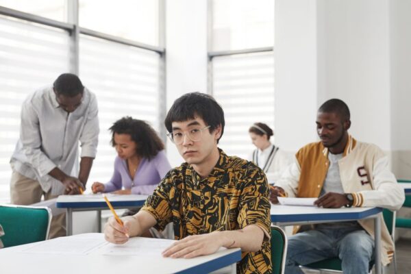 Diverse college students focused on an exam in a classroom, illustrating the UPSC NDA and CDS exam context.