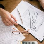 Tax forms marked with scam, illustrating financial fraud risks around GST guidance deadlines.