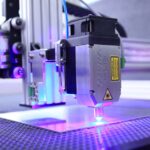 An industrial laser engraving machine in action, illustrating the Pentagon's laser weapon prototype funding.
