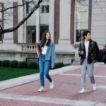 Young students stroll along a sunny campus sidewalk, illustrating the IndiaAI Fellowship 2026 launch.