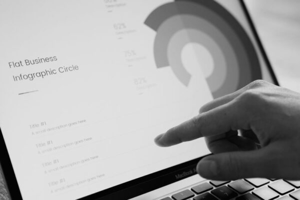 A finger pointing at a grayscale infographic on a laptop screen, illustrating Apple's new touch controls for the MacBook Pro.