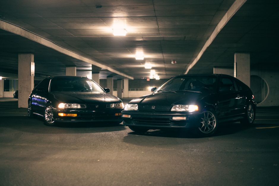 Stock photo of two vintage Honda cars parked in a dimly lit indoor garage at night, showcasing, used to illustrate this story on Honda Warns 50% Canada Auto Tariffs Would Be Catastrophic.