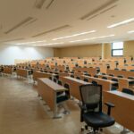 Rows of wooden desks and chairs in a large empty university lecture hall, illustrating the decline in Australia’s appeal as a study destination.