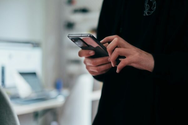 A person holding a black Android smartphone, illustrating the article's tips on consumer-friendly AI agents.