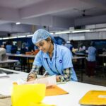 A factory worker writing at a desk, illustrating research on self-employed income and benefit-form rules.