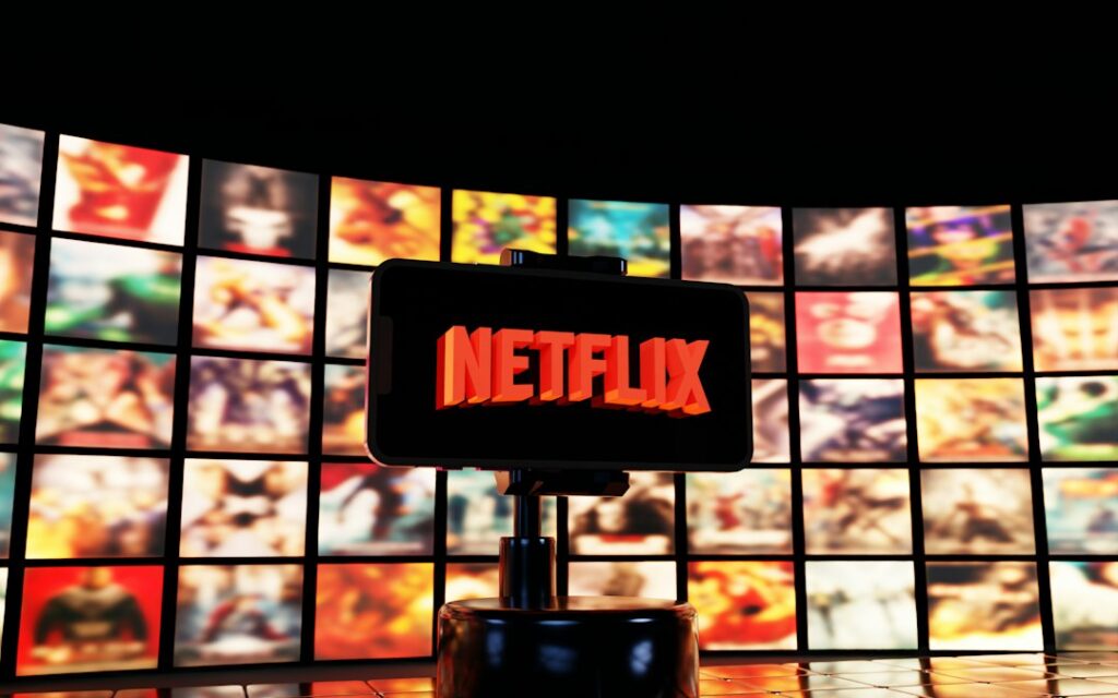 Netflix logo on a screen with movie posters, illustrating the streaming service's brand presence.
